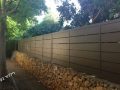 גדר מאלומיניום חום מעל חומת אבן